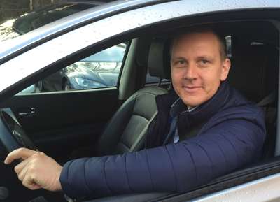 Roger Ytre-Hauge kikker i kamera fra bak rattet på en bil (Foto)