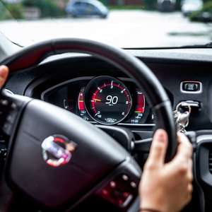 En sjåfør vrir på rattet til en bil (Foto)