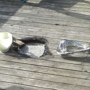 Hull i terassegulv etter brann fra engangsgrill