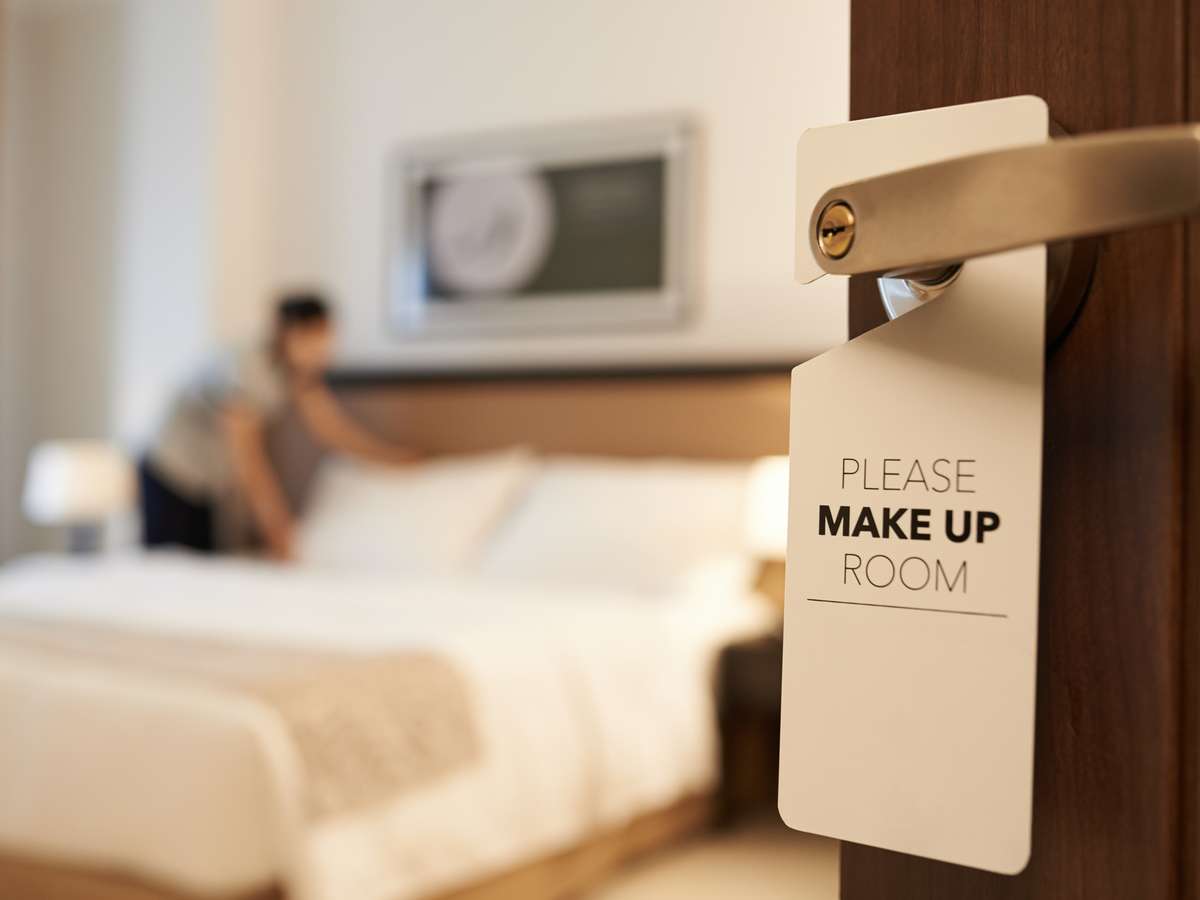 Ansatt rere opp sengen på hotellrom