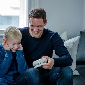 Sønn og far sjekker batteriet i røykvarsleren