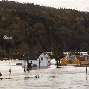 Flom_iStock-lillitve Houses standing in the flood water at Drangsholt. Flooding from the river Tovdalselva in Kristiansand, Norway - October 3, 2017.