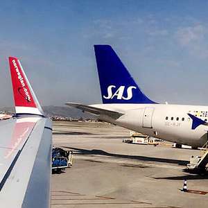 Et SAS og et Norwegian fly står ved siden av hverandre på en flyplass (Foto)