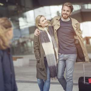 Smilende par på flyplass