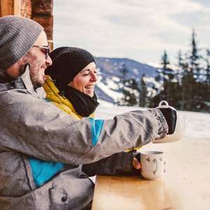 Par slapper av på en benk utenfor hytten