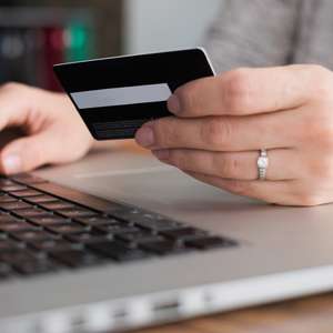 Med innboforsikring i Frende hjelper vi deg ved ID-tyveri - person med datamaskin og kredittkort