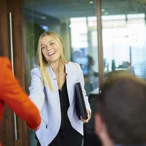 Kandidaten håndhilser på de som skal intervjue henne før et intervju (Foto)