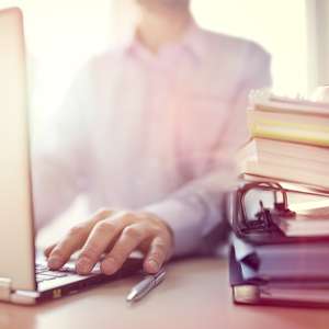 Person med permer foran PC.jpg