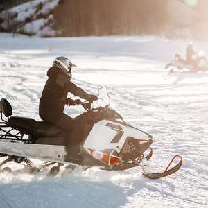 Person kjører snøscooter. Foto.