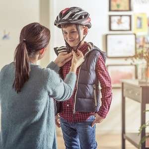 Mor tar på sykkelhjelm på sin sønn