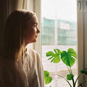 Kvinne som ser ut vindu. Illustrasjonsfoto uføreforsikring.