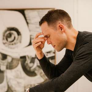 Mann ser sliten ut og tar seg til hodet (Foto)