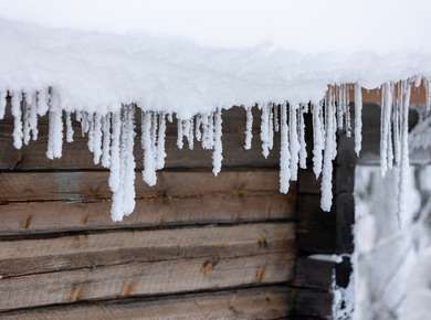 Istapper henger tungt fra et snødekt hyttetak (Foto)
