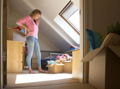 Ung kvinne pakker ut i ny leilighet