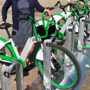 Kvinne parkerer en bysykkel (Foto)